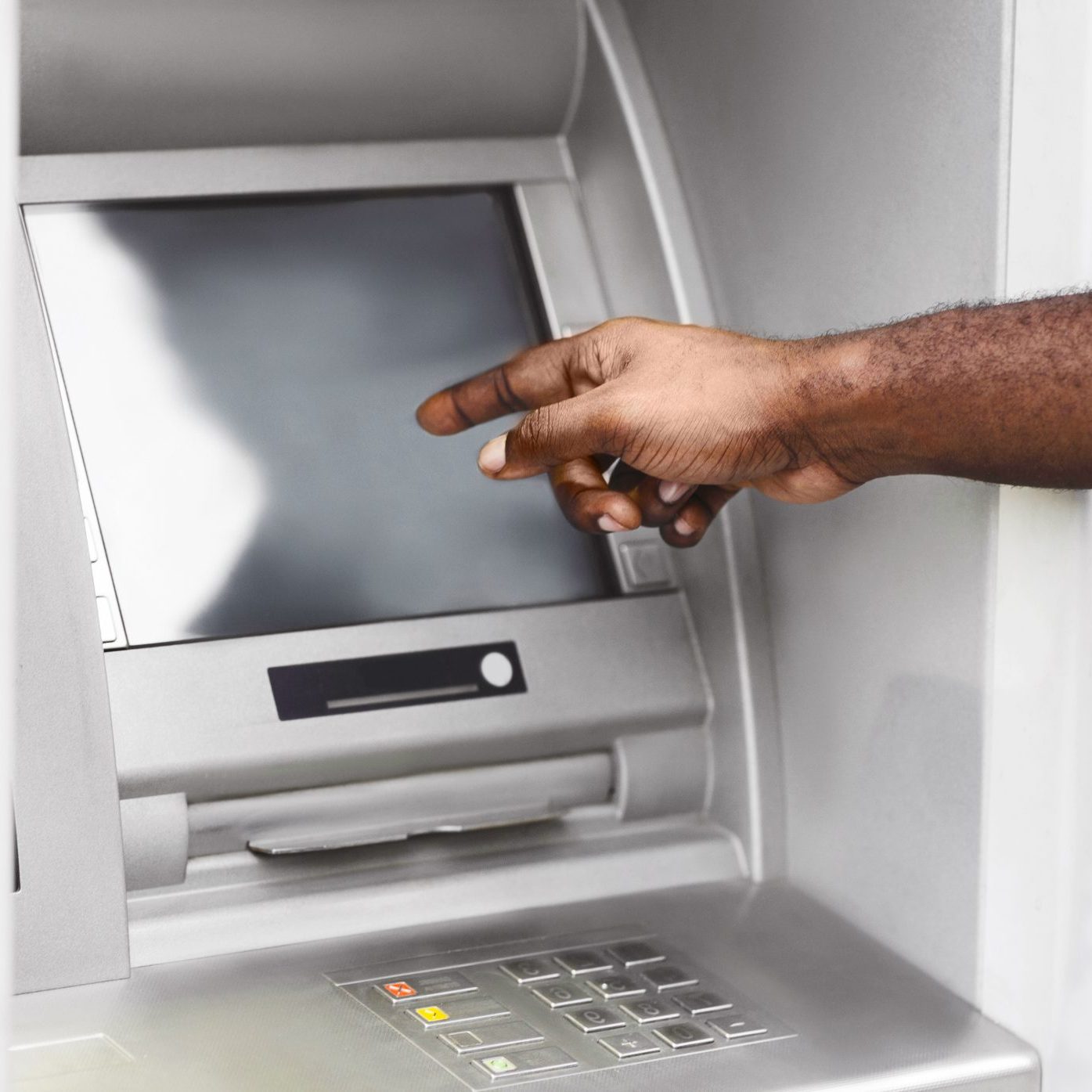 A close-up of a persons hand interacting with an ATM screen. The persons arm and shoulder are visible in the background.