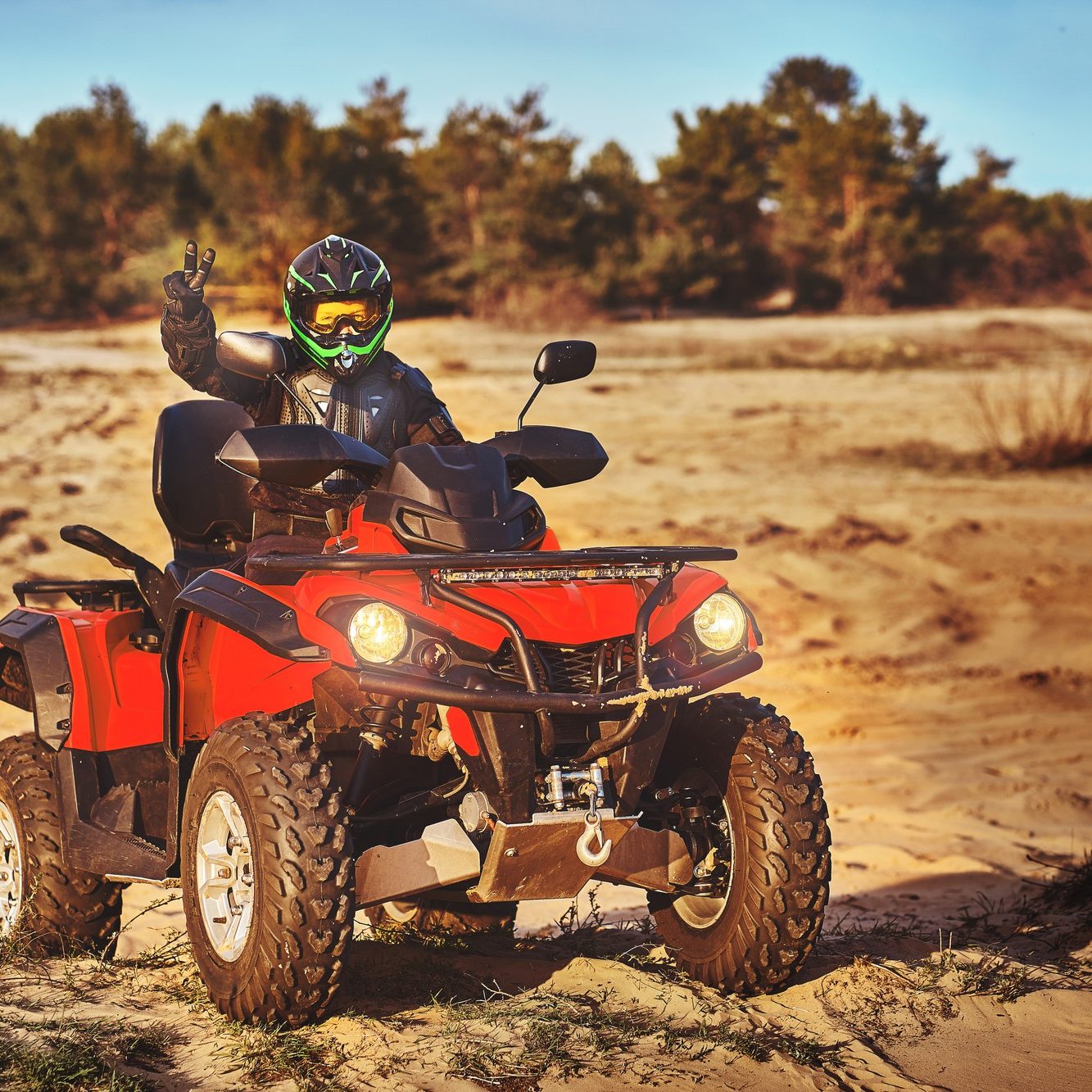 teen-riding-atv-sand-dunes-making-turn-sand