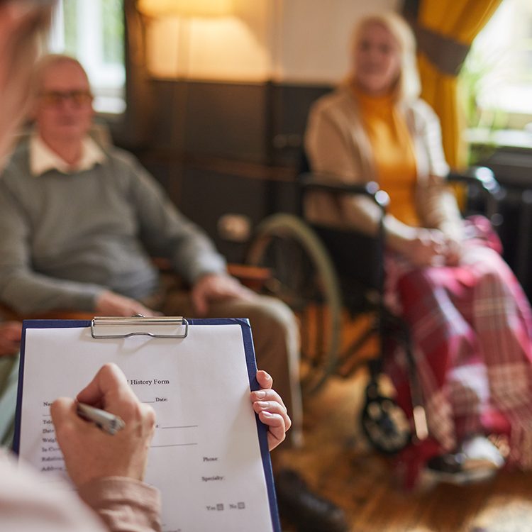 Close up of young woman writing on clipboard during therapy session at retirement home, copy space
