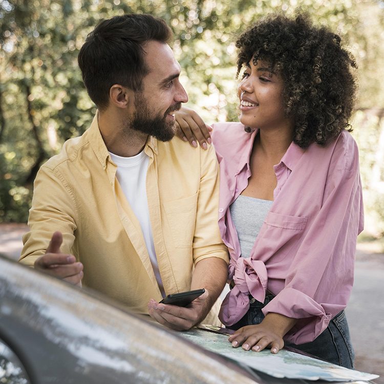 smiley-couple-outdoors-with-map-smartphone